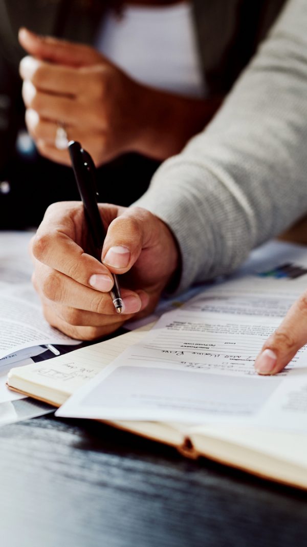 Closeup shot of an unrecognizable couple going through paperwork together at home